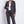 Load image into Gallery viewer, Woman wearing a gray suit against a white brick wall
