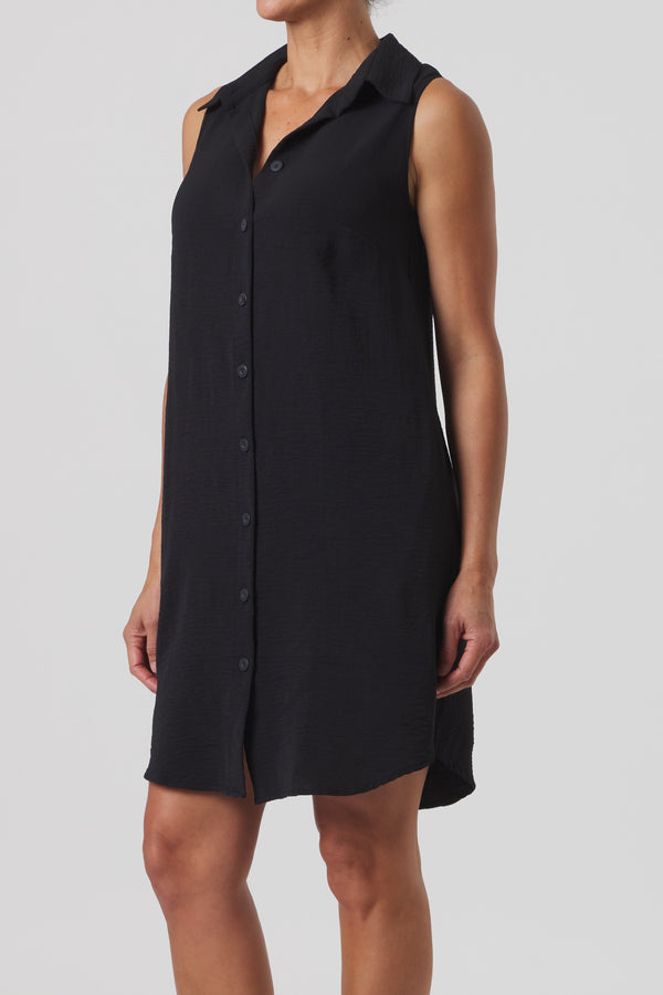 Black sleeveless dress worn by a model on a light gray background