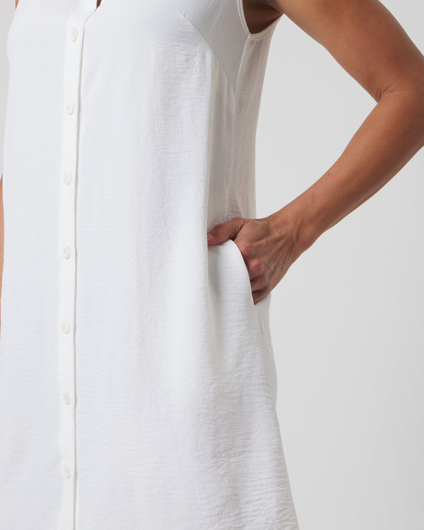 White sleeveless dress worn by a person on a plain background